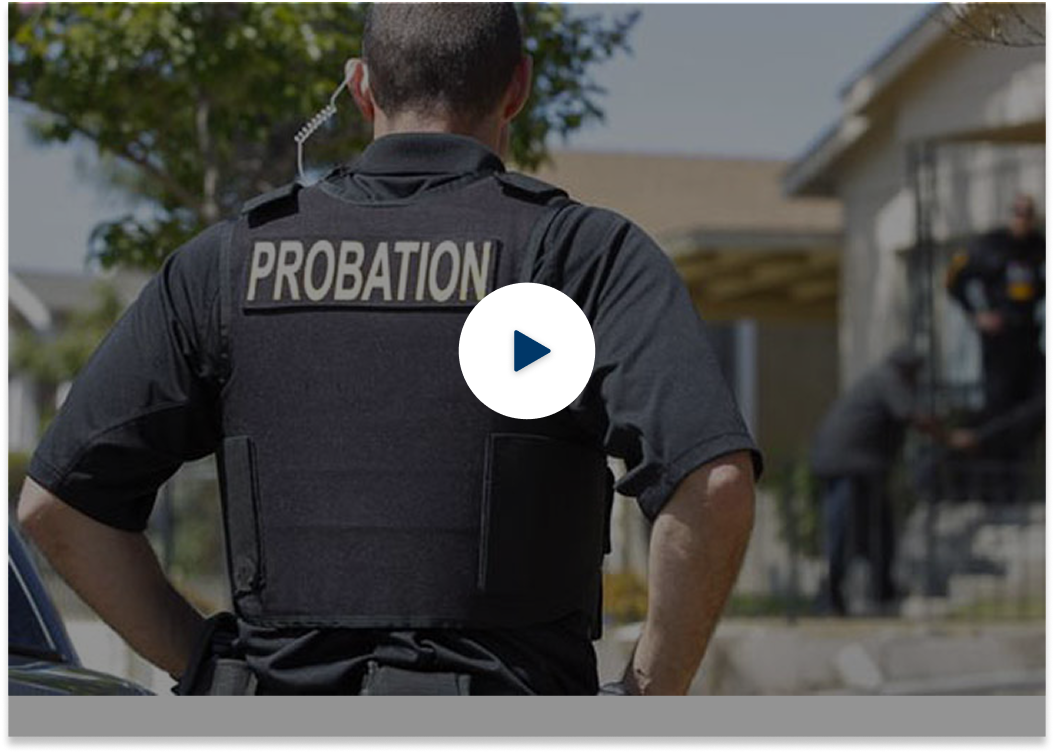 Agente de libertad condicional de pie mirando hacia el fondo y el icono de reproducción en el centro de la imagen.